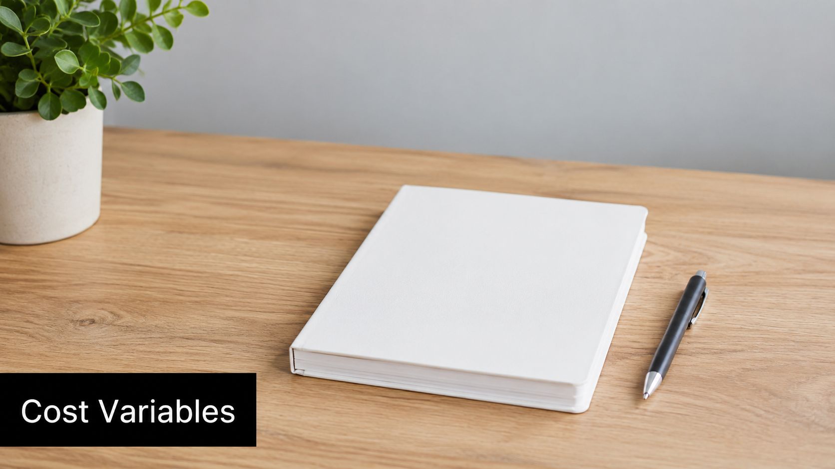 A blank white notebook and a black pen on a wooden desk with a small plant.