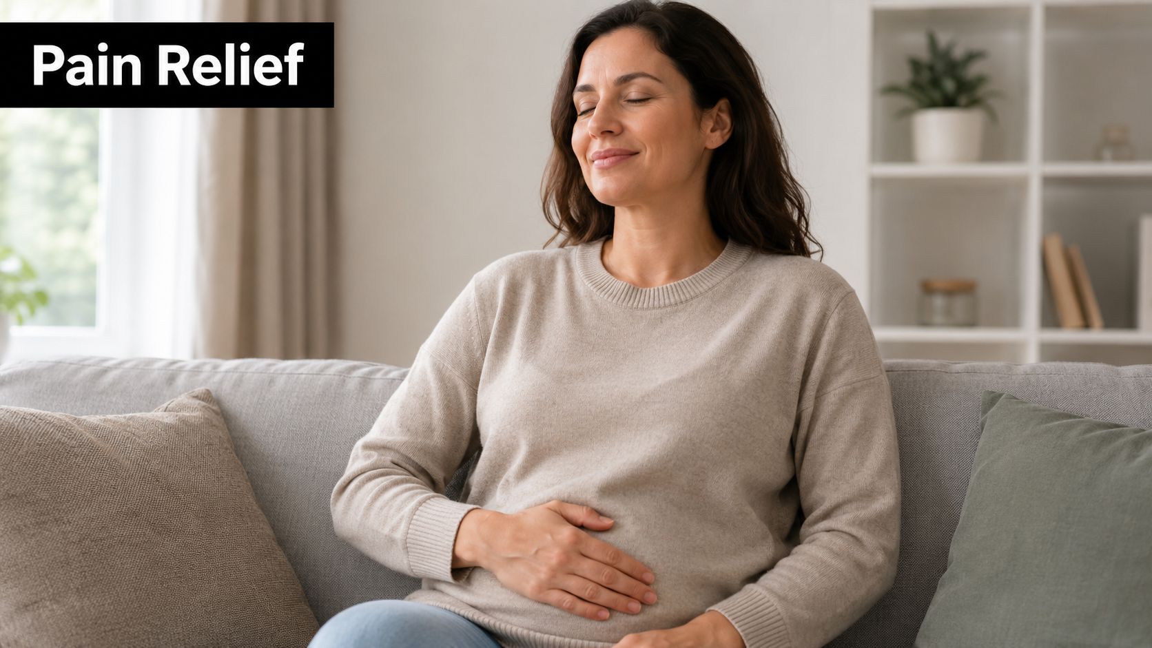 A pregnant woman sitting on a couch and holding her stomach in a serene and comfortable manner.